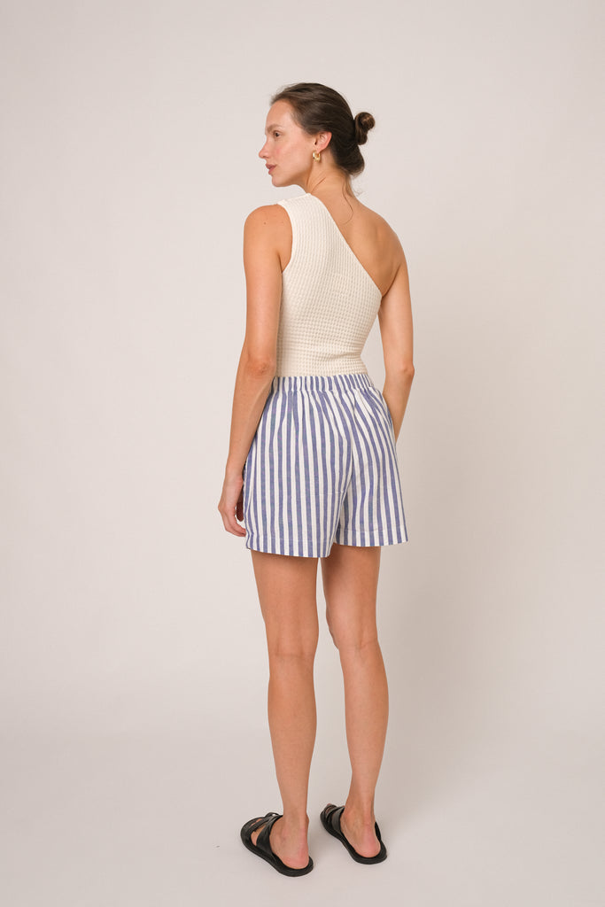 Short feminino listrado, com listras azul e branco, e botões frontais. 